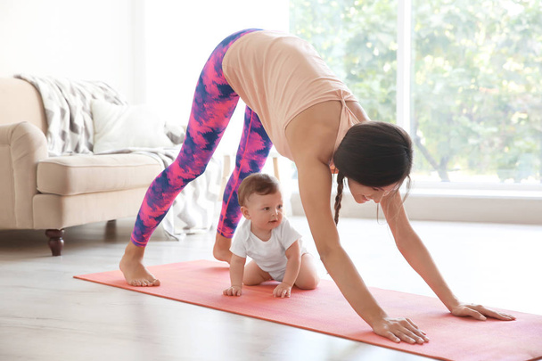 Young mother doing yoga with baby  - Фото, зображення
