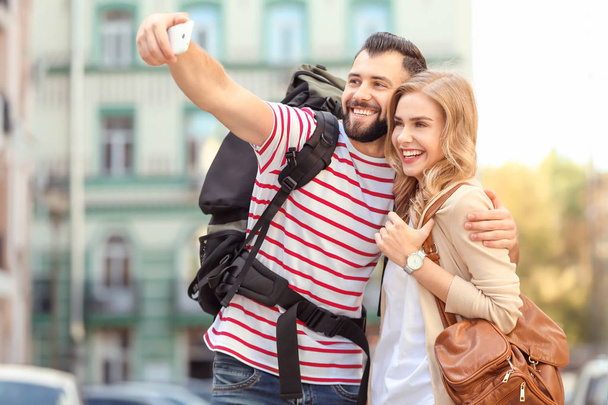 Couple of young tourists taking selfie on the street - Foto, Imagem