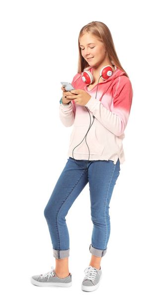 Cute teenager girl with mobile phone and headphones on white background - Foto, Imagem