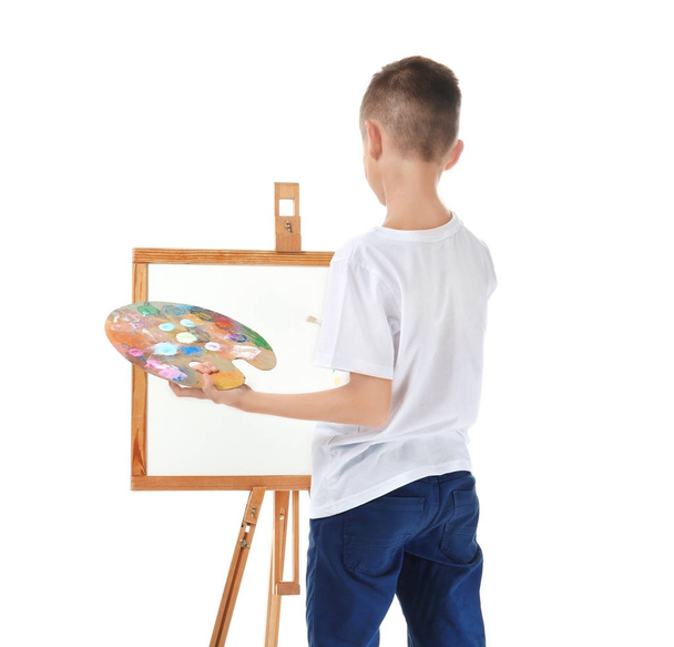 Cute little boy painting picture on canvas against white background - 写真・画像