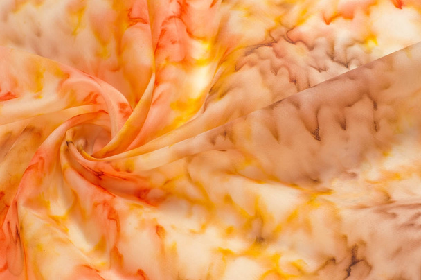 Texture, fond, motif. Tissu en soie avec un motif jaune rouge flou. Fleurs jaunes, rouges et crème sur blanc
 - Photo, image