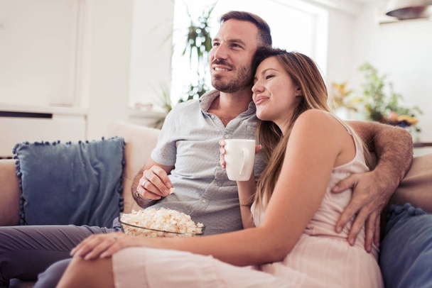 Couple sitting together on sofa at home - Photo, image