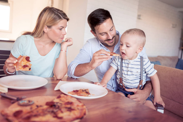 Family with pizza in kitchen. - Photo, Image