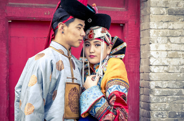 Монгольська пара в традиційних спорядження поблизу старий храм в Улан-Баторі в традиційних спорядження поблизу старий храм в Улан-Батор - Фото, зображення