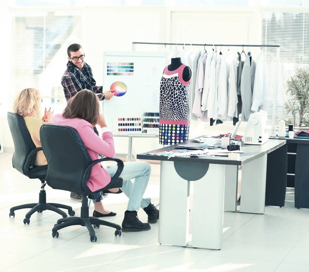 modern designer and his team choose the fabric for clothes in office - Foto, Bild