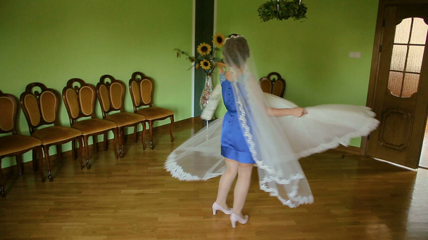 Mujer atractiva joven eligiendo vestido de novia, posando y probándose
 - Imágenes, Vídeo