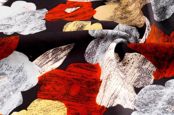 Texture, fond, motif. Le mouchoir en soie d'une femme est décoré de couleurs vives. Fleurs blanches jaunes rouges sur fond noir
 - Photo, image