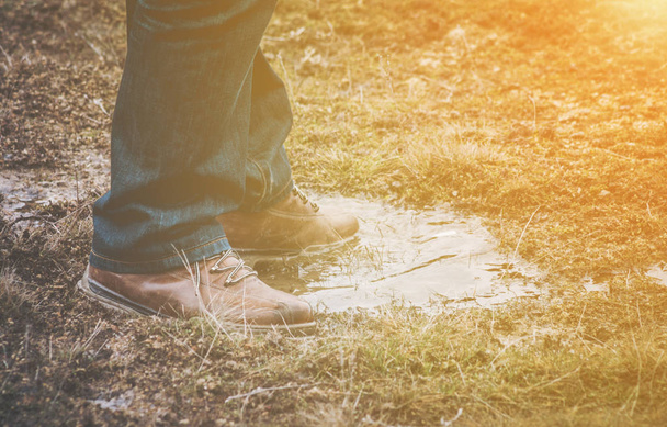Feet of a person standing in a puddle of water - Photo, Image