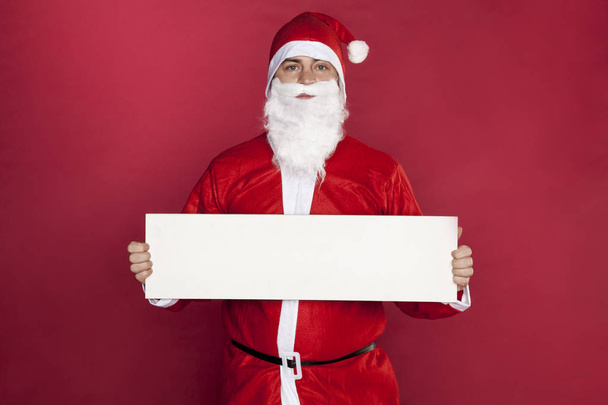 Disappointed Santa Claus keeps advertising in front of him, - Photo, Image