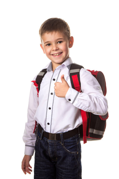 Alegre chico de escuela con mochila, con el pulgar hacia arriba, el amor de ir a la escuela sobre fondo blanco
 - Foto, Imagen