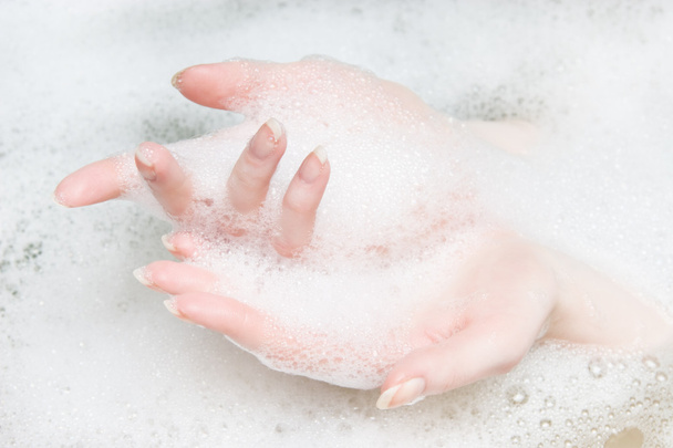 Woman hands in a bath with foam - Фото, изображение