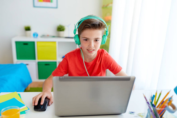 boy in headphones playing video game on laptop - Zdjęcie, obraz