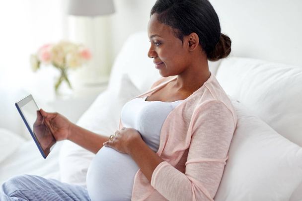 happy pregnant woman with tablet pc at home - Foto, immagini