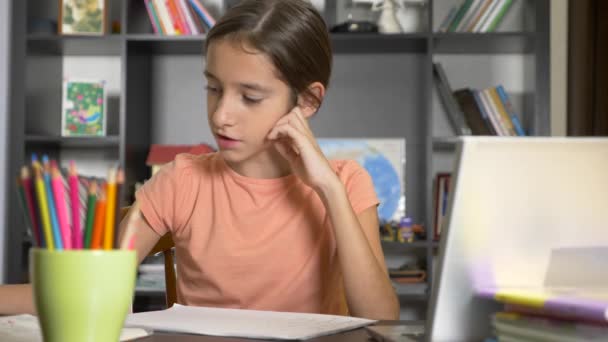 concept of online learning. the child is enrolled in an online school. girl doing homework with laptop. 4k, slow motion - Záběry, video