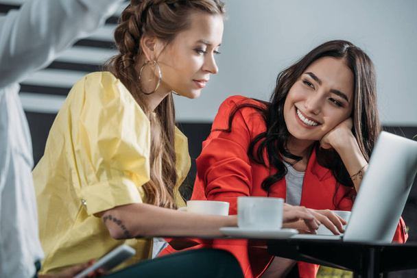 giovani donne che lavorano con il computer portatile insieme nel caffè
 - Foto, immagini