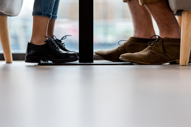 cropped image of father and daughter legs under table - Photo, Image