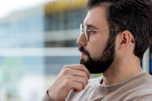 retrato de hombre guapo pensativo tocando la barba y mirando hacia otro lado
 - Foto, Imagen