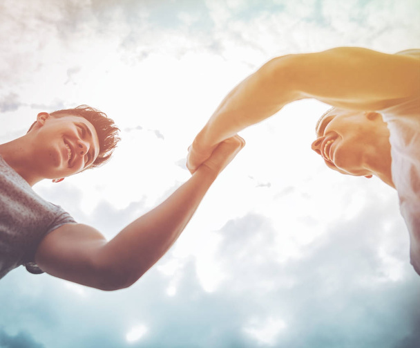 Two friends giving high five on sky background, motivation and success - Photo, Image