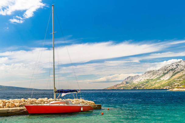 Zeilboot verankerd aan de kust van de Adriatische Zee in de buurt van Brela. - Foto, afbeelding