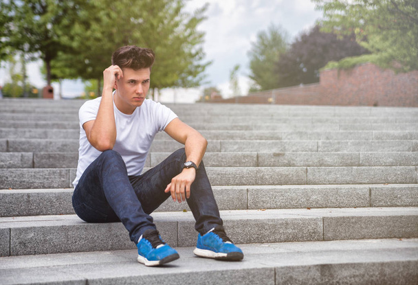 Handsome young man outdoor on stairs in town - Photo, image