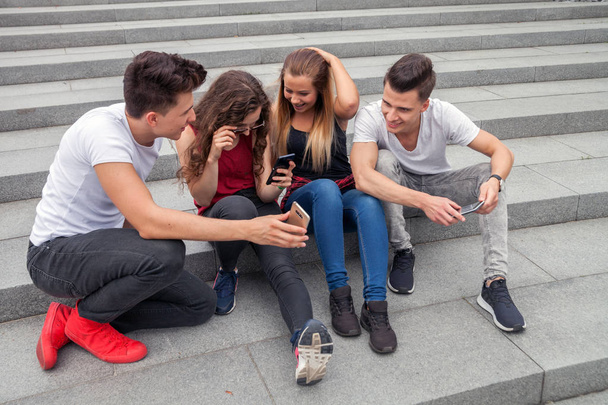 Группа друзей, сидящих вместе, используя свои телефоны
 - Фото, изображение