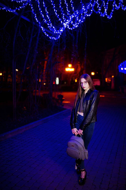 Night portrait of girl model wear on glasses, jeans and leather  - Fotó, kép
