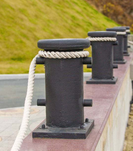 bollards with ropes on a quay for decorative fencing. - Photo, Image