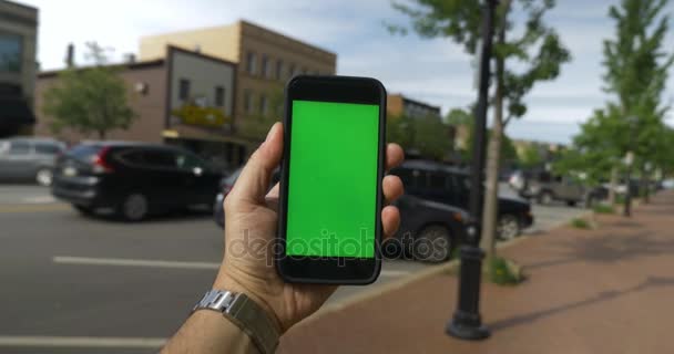 POV поворот в маленьке місто з зеленим екрану смартфона - Кадри, відео