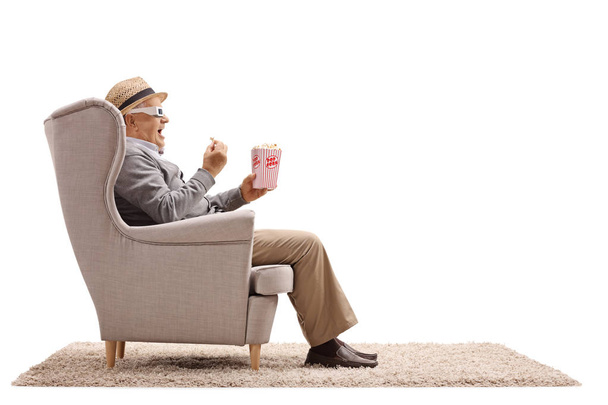 man with 3-D glasses and having popcorn in an armchair - Valokuva, kuva