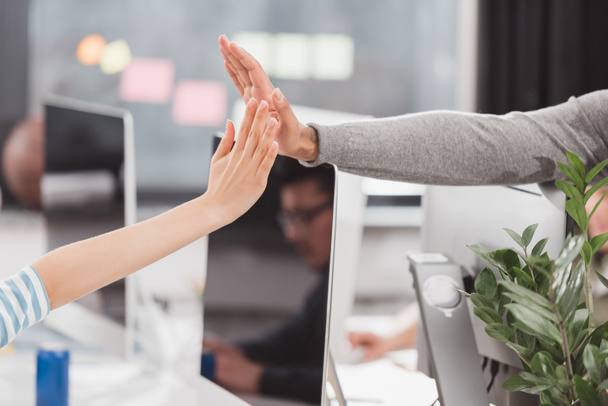 cropped image of hands giving high five to each other at modern office - Fotoğraf, Görsel