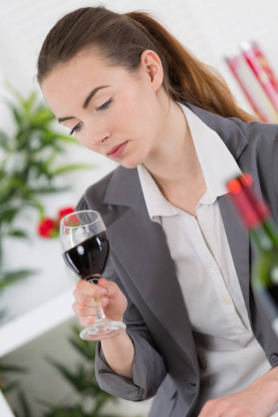 woman in suit looking into glass of red wine - Fotografie, Obrázek