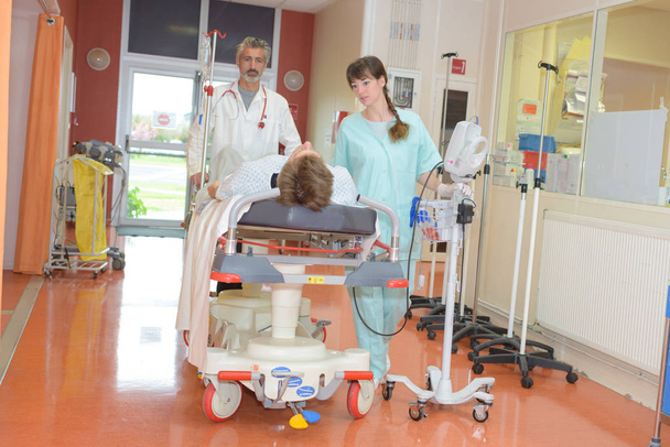 työntekijät, jotka siirtävät potilaita sairaalaan
 - Valokuva, kuva