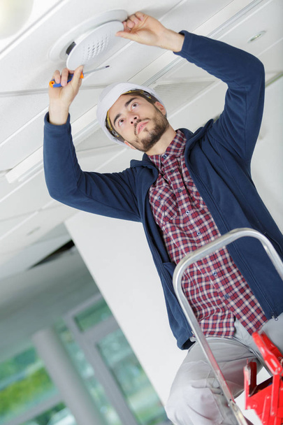 technician install vent on ceiling in office - Fotografie, Obrázek