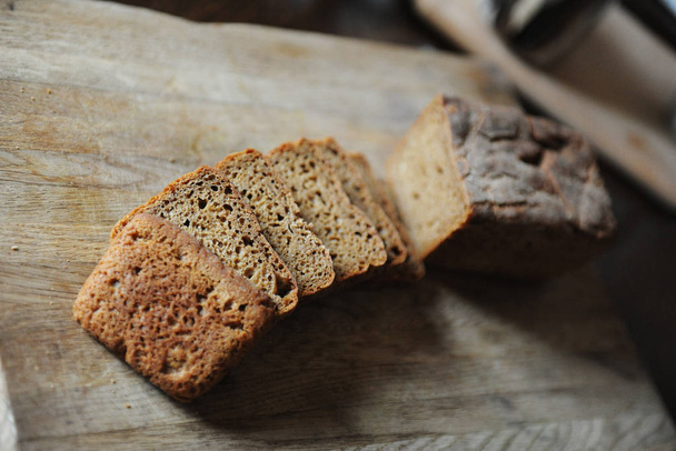 Fresh homemade unleavened bread on the leaven is sliced on a wooden board. Serving of breakfast - Фото, изображение