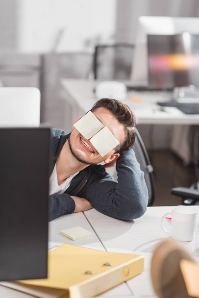 happy man with stickers on eyes at office - Photo, Image
