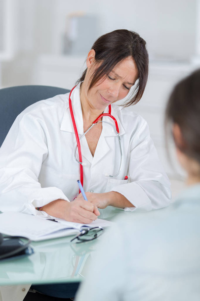 female doctor listening to her patientin office - Foto, immagini