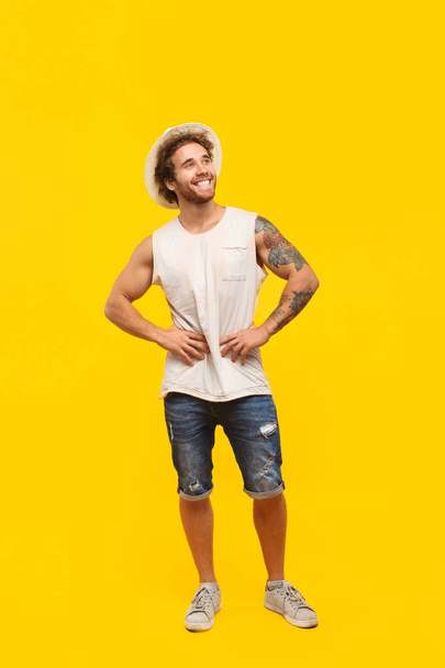 Smiling hipster posing on yellow - Фото, изображение