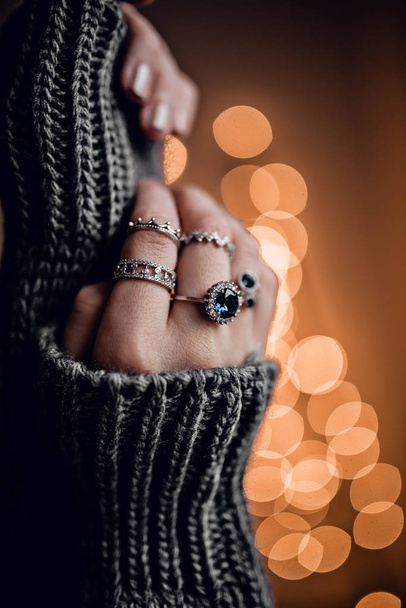 Hands with rings on golden bokeh lights background - Foto, immagini