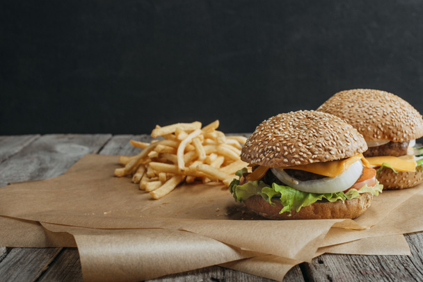 tradycyjne cheeseburgery domowe na pieczenia papieru z frytkami - Zdjęcie, obraz