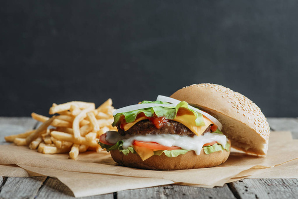 traditional homemade burger on baking paper with french fries - Photo, Image