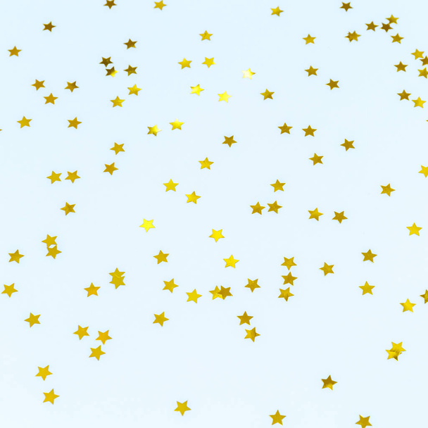 Golden star sprinkles on blue. Festive holiday background. Celeb - Photo, Image