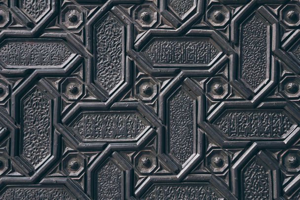 κοντινή λήψη ενός μαύρου τοίχου με σκαλιστά αραμπέσκ σχέδιο - Φωτογραφία, εικόνα