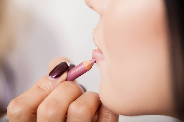 Maquilleur professionnel appliquant du rouge à lèvres
 - Photo, image