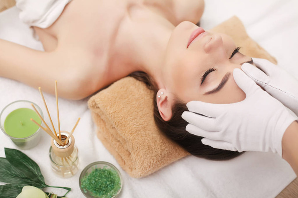Giovane bella donna godendo procedura di massaggio facciale - Foto, immagini