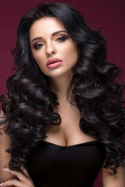 Beautiful brunette model: curls, classic makeup, gold jewelry and red lips. The beauty face. - Foto, Imagem