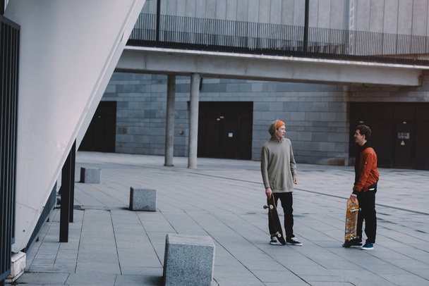 skateboarders talking after ride in modern urban location - Foto, Bild