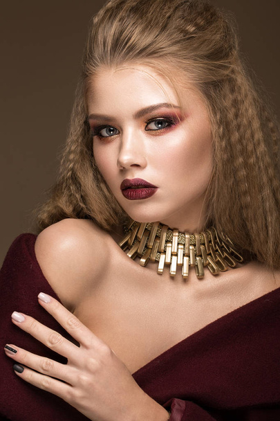 Beautiful blond model: curls, bright makeup, gold jewelry and red lips. The beauty face. - Valokuva, kuva