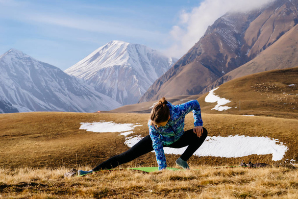 active sports girl engaged in yoga in the Caucasus mountains, enjoys nature and tourism - Photo, Image
