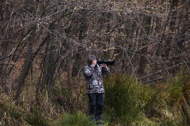 professional photographer with camouflage outfit in nature - Photo, Image