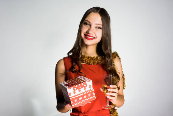 Szczęśliwa dziewczyna z okazji nowego roku i Boże Narodzenie, trzyma kieliszek z szamanem i prezent - Zdjęcie, obraz